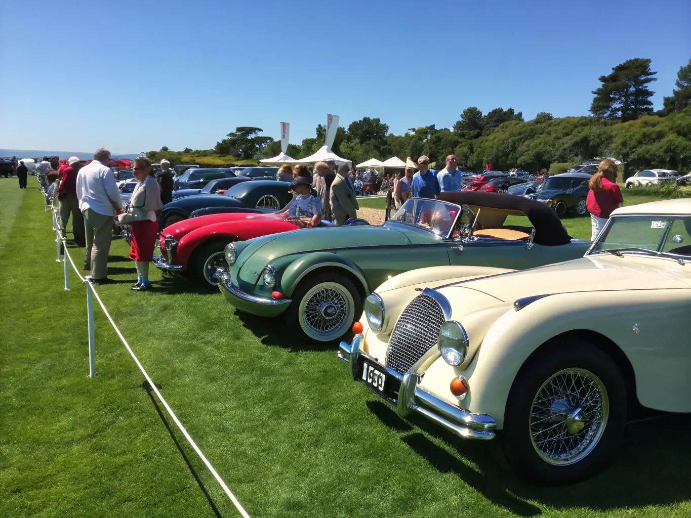 Enthusiasts gathered at a car show, admiring and discussing the features of various classic vehicles, reflecting EGCH's role in community engagement.